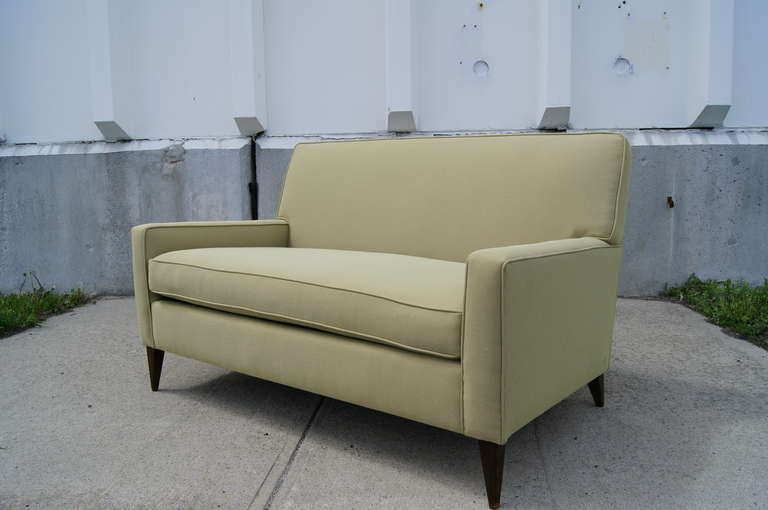 This petite settee by Paul McCobb is newly reupholstered in Knoll textile and features tapered wood legs.