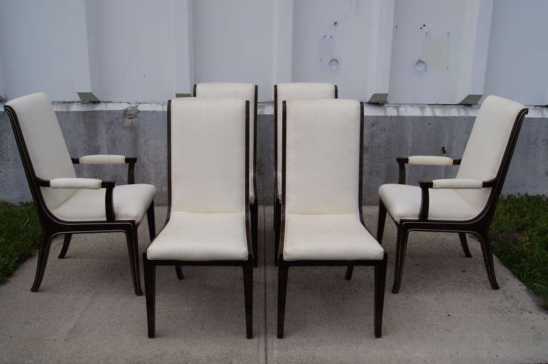 Designed by William Doezema, a cofounder of Mastercraft, this striking set includes two armchairs and four armless dining chairs. The chairs are constructed of beautiful dark amboyna burl wood with subtle brass inlay and are upholstered in an