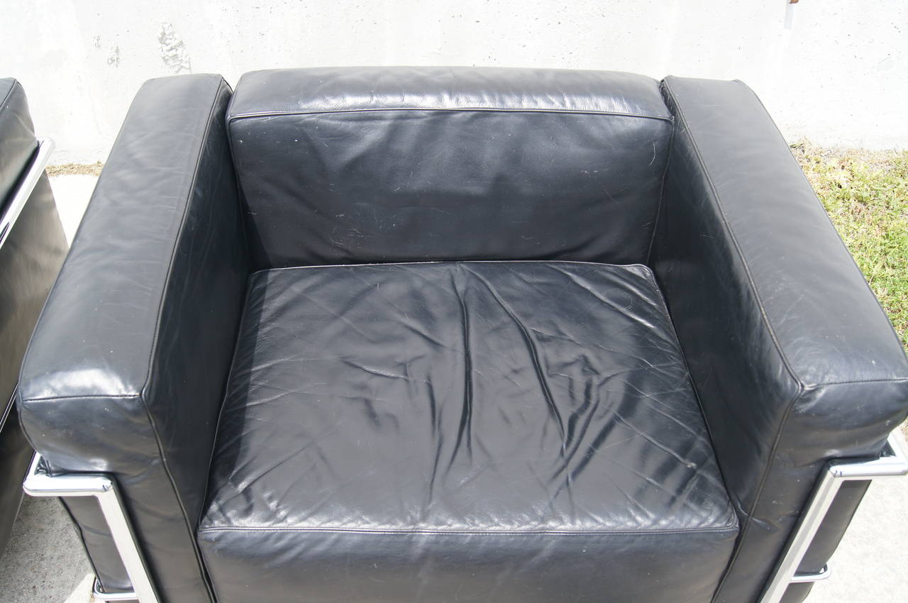 Designed by Le Corbusier in 1928, this modern club chair is composed of a chrome frame and four black leather cushions.