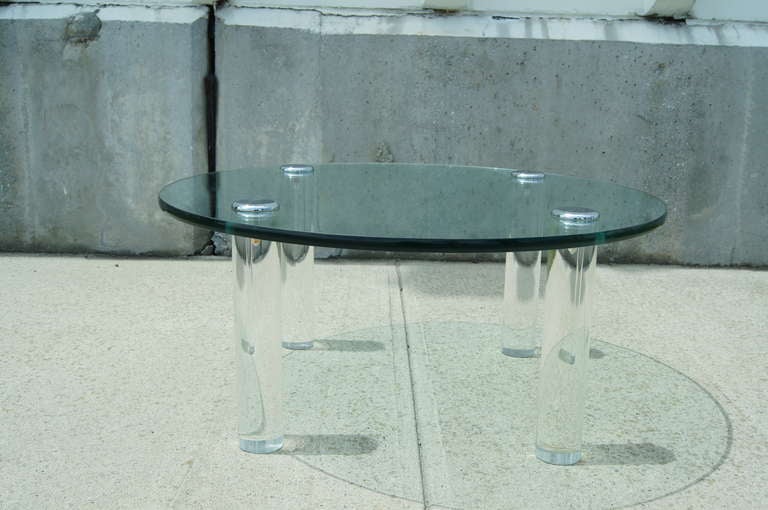 This Pace coffee table is composed of a round glass top that sits atop four solid lucite legs. The glass in 36