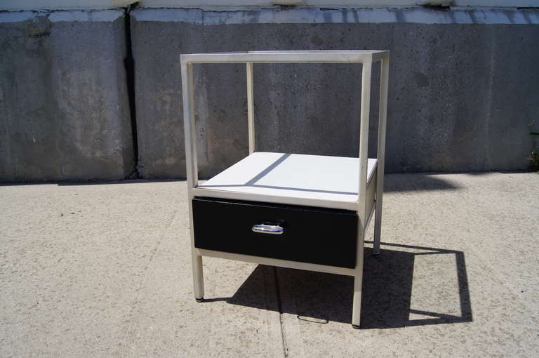 This nightstand by George Nelson for Herman Miller is constructed of an enameled steel frame with a glass top and a painted black drawer. The drawer features the original manufacturer's label.