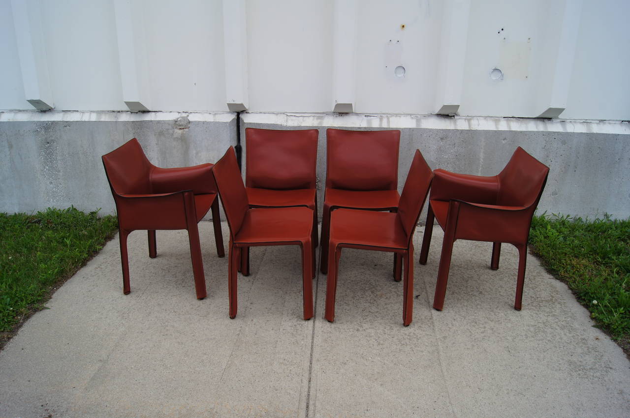 Set of two 413 Cab armchairs and four 412 Cab armless dining chairs. 

The Cab Chair by Mario Bellini is widely recognized as one of the more significant chair designs of the twentieth century. A version of the Cab Chair is featured in the MOMA's