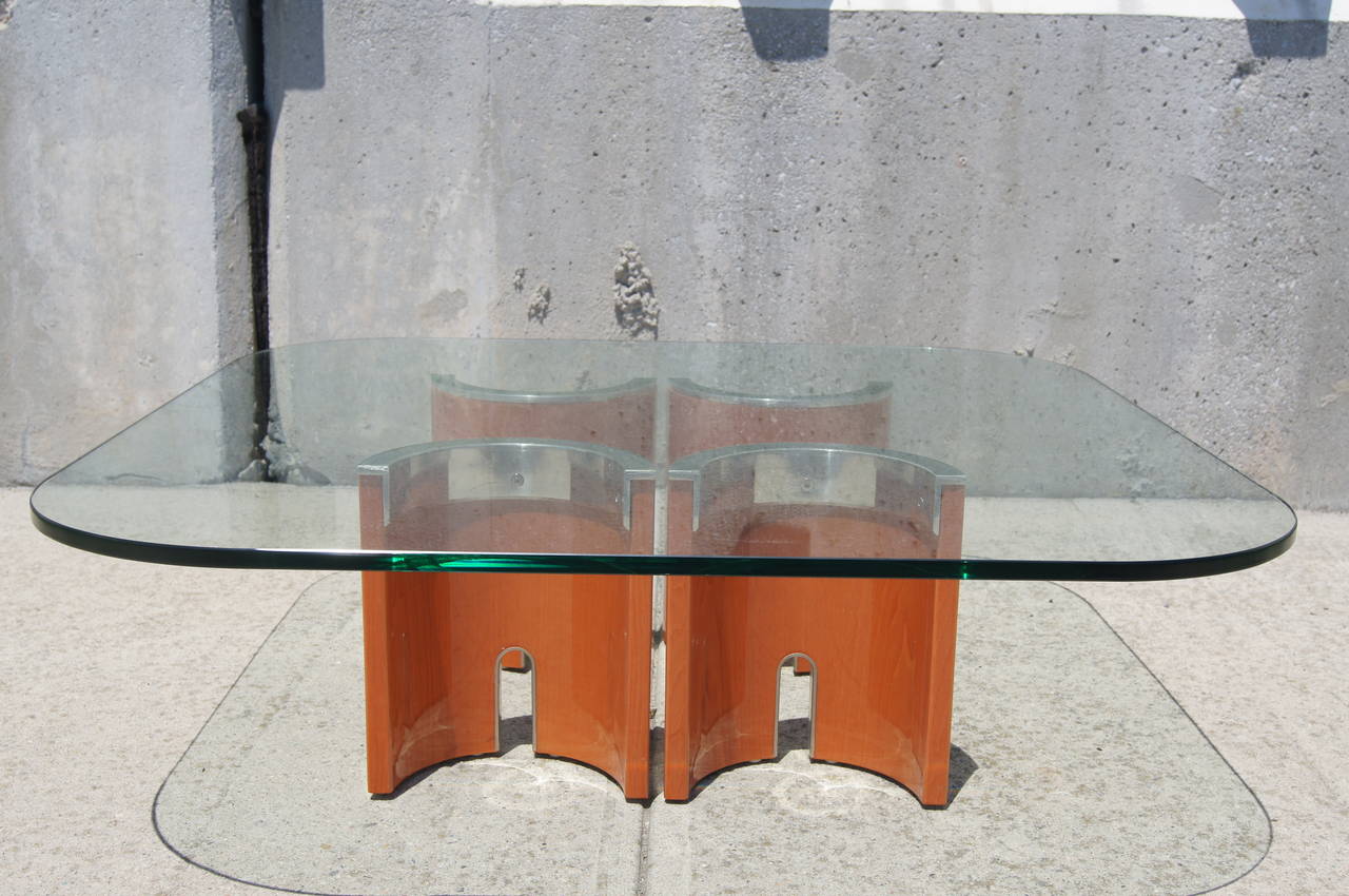 A fabulous example of the Saporiti Italia aesthetic of the 1970s, this low coffee table by Giovanni Offredi comprises a square glass top, with rounded edges, that is permanently fixed (with invisible adhesive) to four stainless steel–topped wooden
