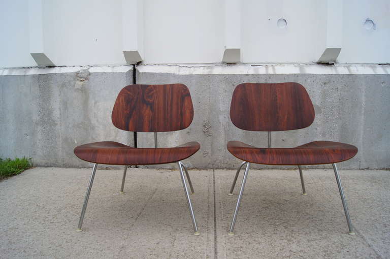 This pair of LCM lounge chairs by Eames for Herman Miller is constructed of rare rosewood that showcases the stunning grain of the wood.