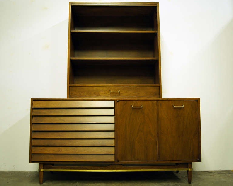 Merton Gershun designed this handsome walnut sideboard and hutch for Martinsville’s Dania collection. On the left of the sideboard, three deep louvered-front drawers create a seamless flow. On the right, two doors with brass pulls conceal three