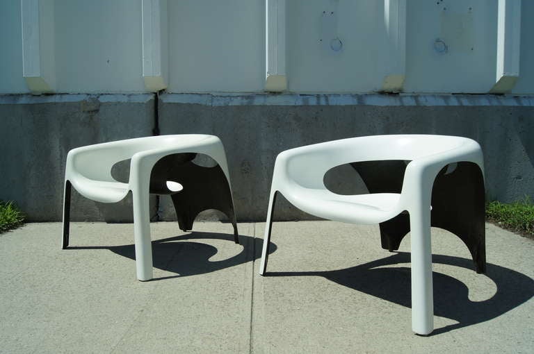 These fantastic chairs from the early seventies evoke a futuristic Space Age. Constructed entirely of fiberglass with a white exterior and black underside, their large, low seats feature drains that make them perfect for use poolside or elsewhere