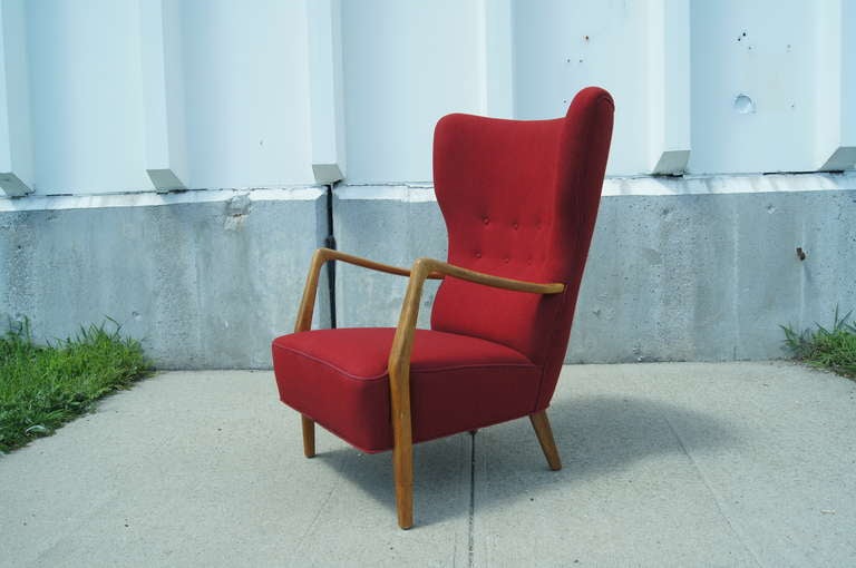 This armchair features a deep seat with a high, slightly winged back and oak arms and legs. It is in excellent, all original condition.