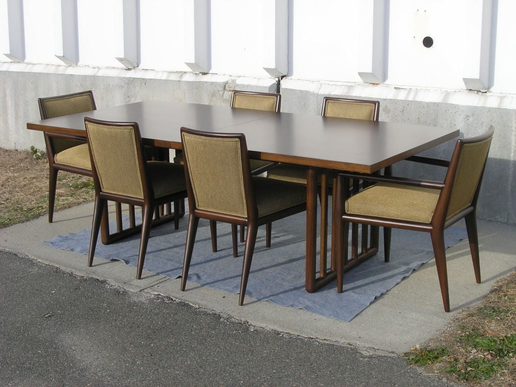 This dining set by T. H. Robsjohn-Gibbings for Widdicomb has a rich presence. Two 12-inch leaves allow the mahogany table to extend from 88 to 112 inches. Completing the set are two arm chairs and four side chairs, elegantly reupholstered in Knoll's