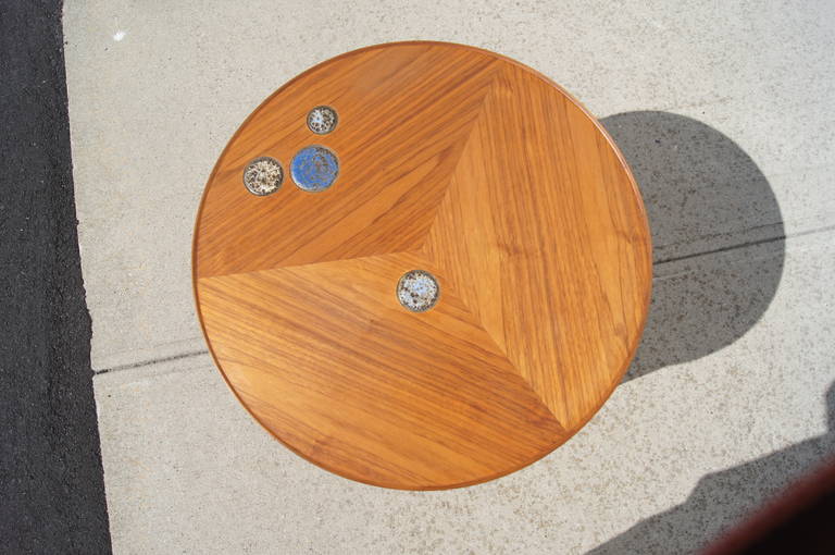 This rare occasional table, which was designed in 1957 by Edward Wormley for Dunbar, is constructed of walnut and features three gently curved legs and round top with four inlaid tiles by Gertrud and Otto Natzler.