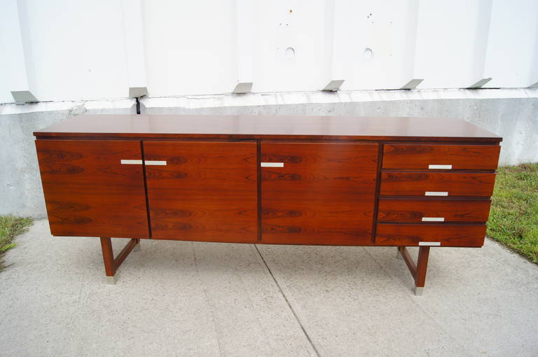 Beautiful rosewood sideboard by Kai Kristiansen with aluminum inlay and aluminum feet. This piece has four drawers and two storage areas, each with adjustable shelving.