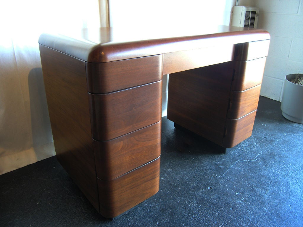 This writing desk by Paul Goldman is constructed of bent plywood, which gives it nicely rounded edges. Even the backs of the drawers are rounded to match the curve of the back of the desk. Designed circa 1945, this desk also comes with unique