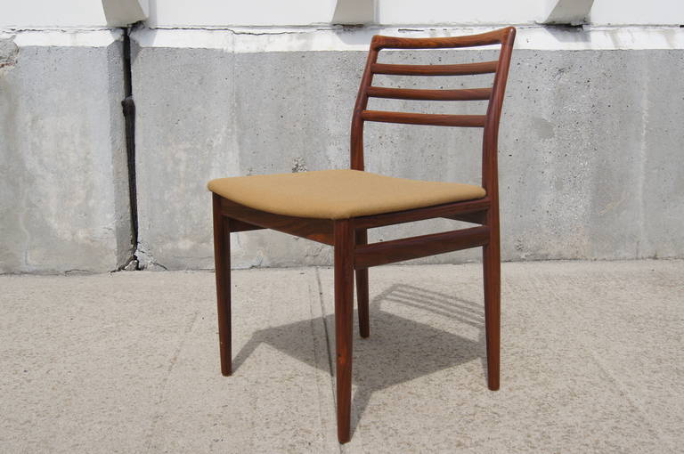 This set of six dining chairs by Niels Moller is composed of solid rosewood, ladder-back frames with seats that feature the original vintage upholstery.