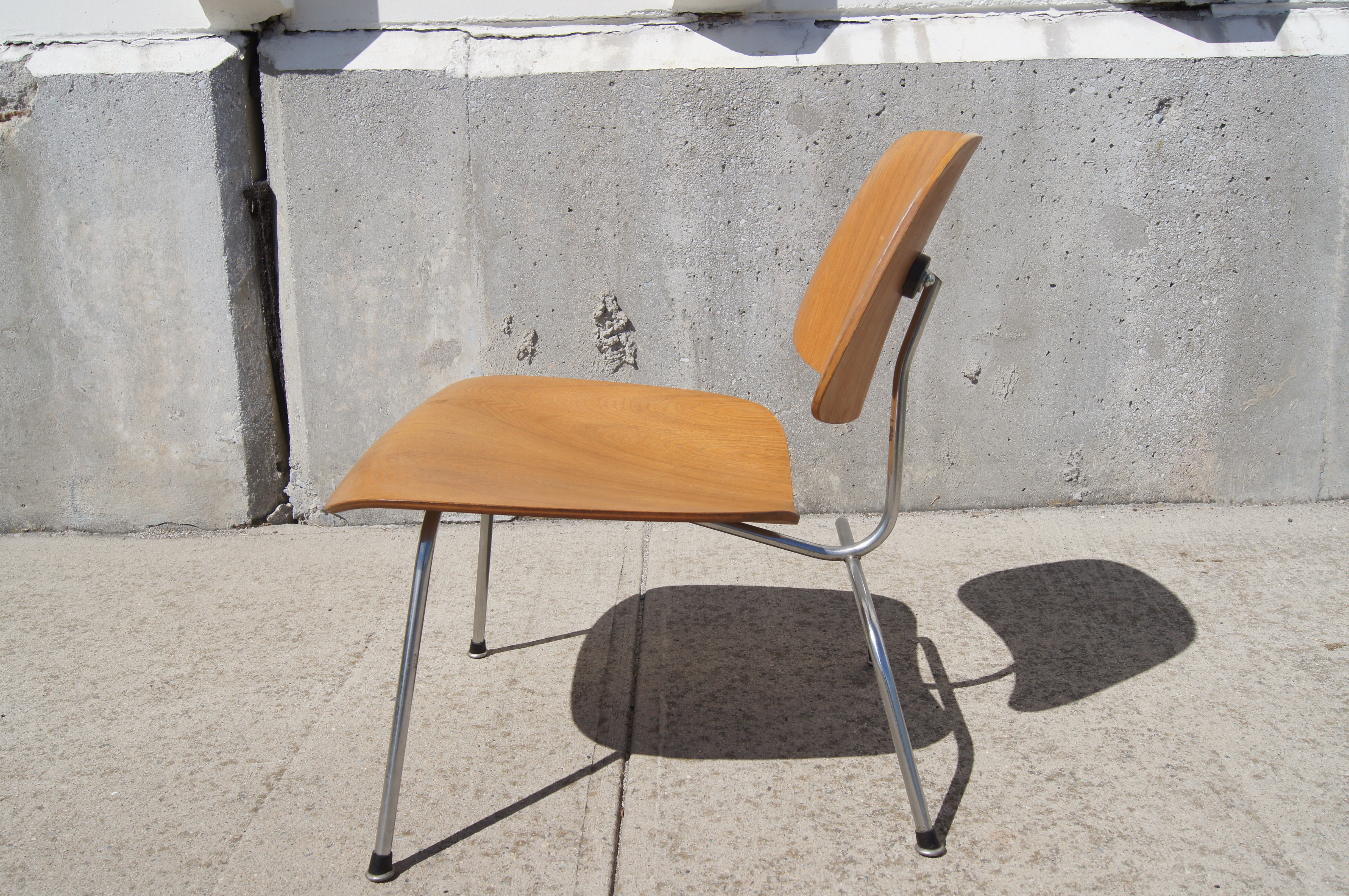 This early 1950s Herman Miller production of Charles and Ray Eames's classic bent plywood LCM chair, in oak and chrome, has all the original parts and is in very good vintage condition.