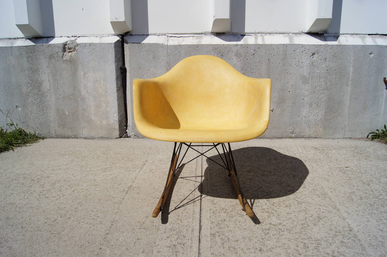 This early rocking chair, the RAR, was designed by Charles Eames and manufactured by Zenith Plastics for Herman Miller. The rope-edge fiberglass shell, in a warm parchment color, sits on a black metal base with birch rockers.

The chair is in very