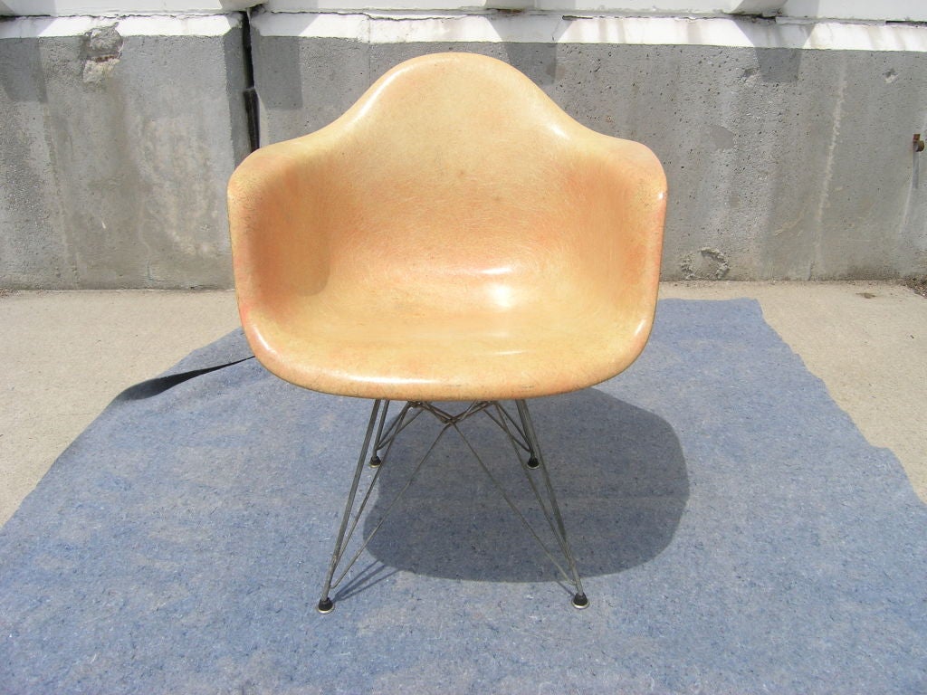 This first-production fiberglass shell armchair was designed by Eames and produced by Zenith Plastics for Herman Miller. Paper label on the underside and steel glides on the Eiffel Tower base.