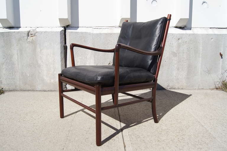 This chair, designed in 1949 and known as the Colonial chair, was inspired by Ole Wanscher's interest in 18th century English furniture. This example is composed of solid rosewood with black leather cushions.