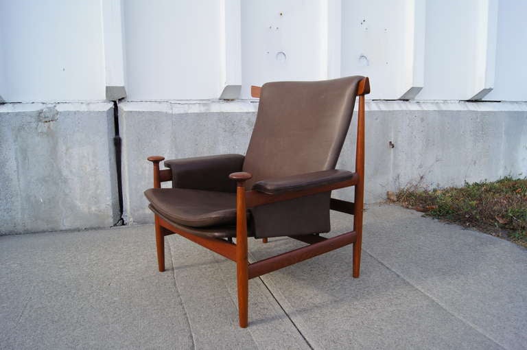 Finn Juhl designed this lounge chair, known as the Bwana Chair, in 1962. Its teak frame cradles a comfortable seat upholstered in rich olive leather. 

This chair is a very early production, with stamps on the frame.