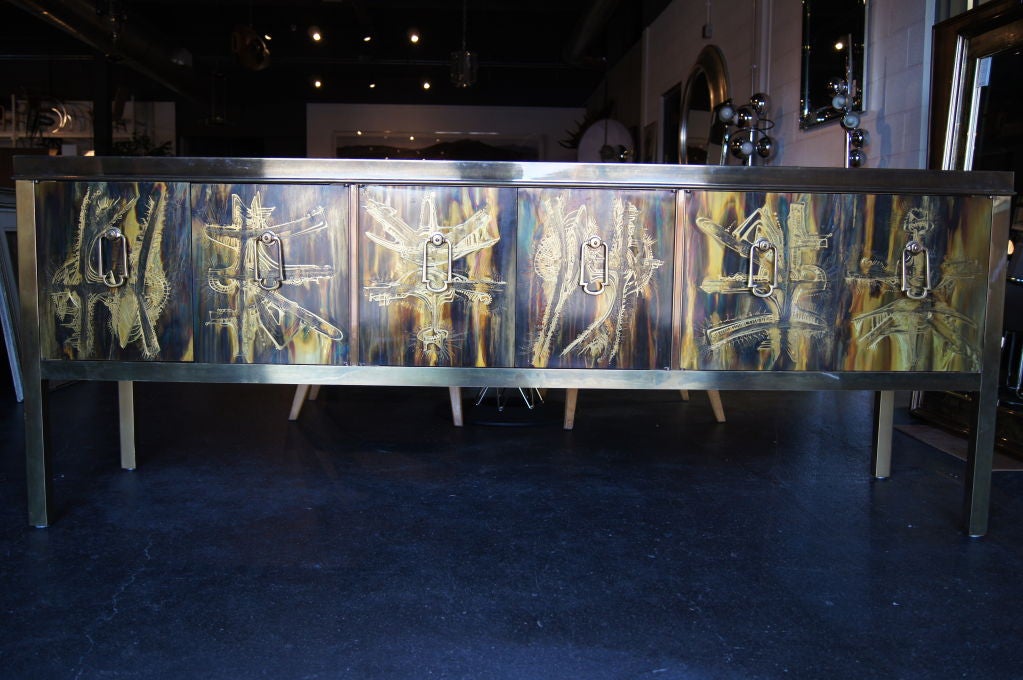 This stunning sideboard is brilliantly decorated with acid-etched designs in iridescent shades. Three cabinets provide ample storage. The first cabinet has a fixed shelf and the second has an adjustable shelf.