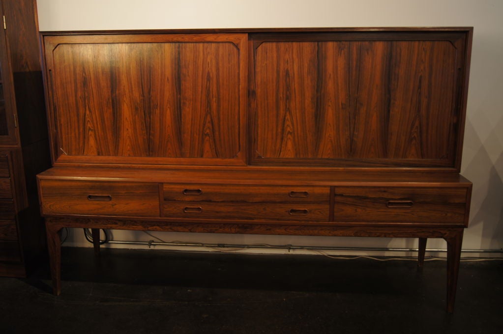 This striking rosewood buffet is the work of Danish furniture designer Severin Hansen Jr., known for his skilled joinery applied to the highest quality materials. The richly grained rosewood case sits on tapered legs. It features four large drawers