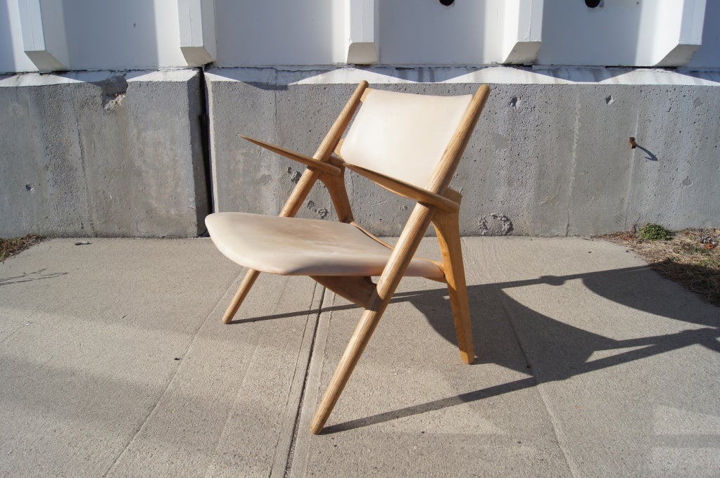 The Classic CH-28 armchair was designed by Hans Wegner in 1951 and was one of the first five designs he created for Carl Hansen & Son. This sawback armchair is upholstered in original leather and is extremely comfortable.