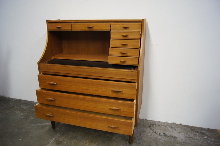 This teak secretary desk by Ivan A. Johansen has three large drawers and seven small drawers. The writing surface extends to provide more work space and retracts to reveal additional storage. Unique drawer pulls enhance the charm of the desk. 