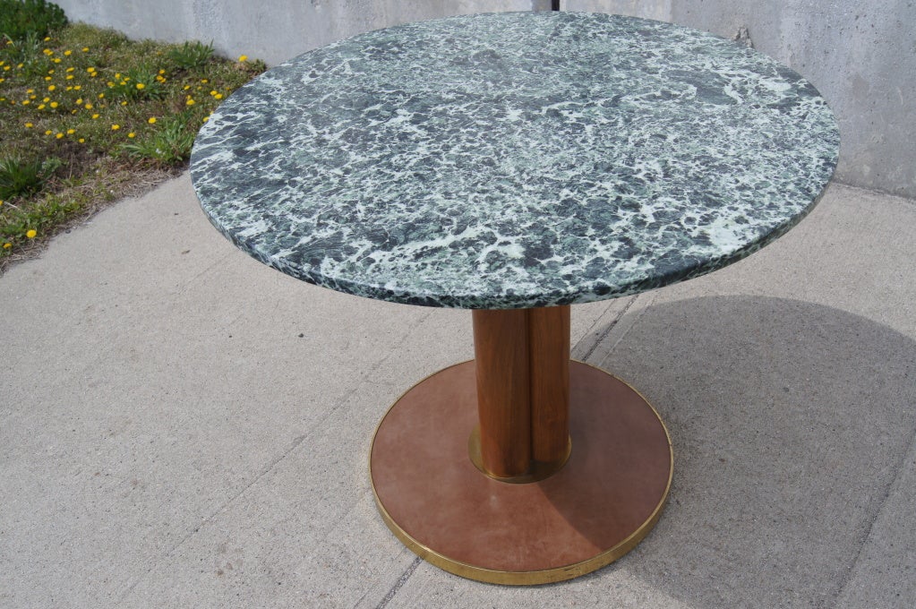 This pedestal table by Edward Wormley for Dunbar would serve equally well for breakfast, tea, or games. A round top of beautiful green Portuguese marble sits on a mahogany trefoil column on a brass-rimmed leather stand.