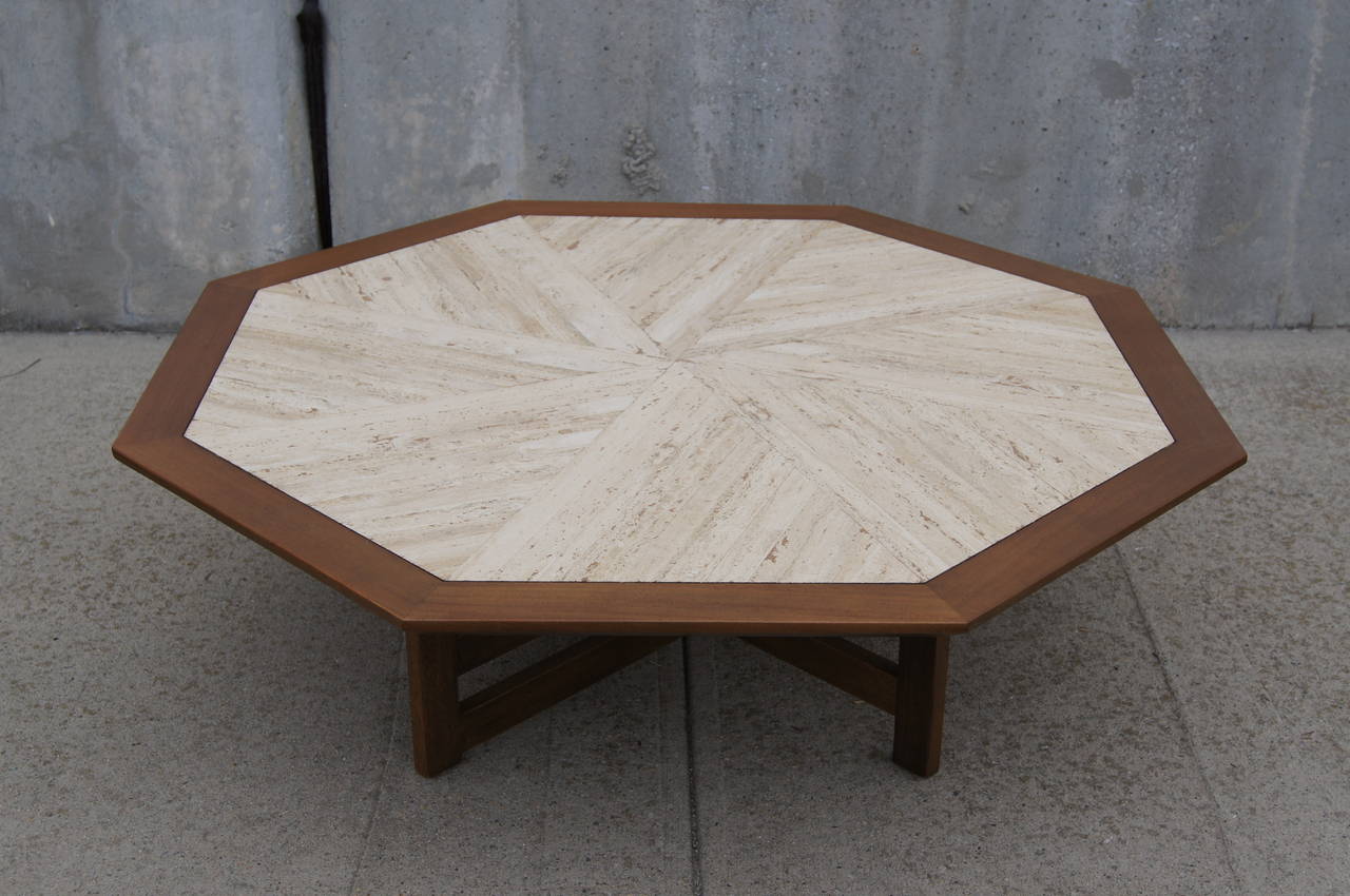 Harvey Probber designed this coffee table with a criss-cross walnut base and an octagonal top with walnut trim and eight inset travertine triangles that together create a swirling geometric effect.