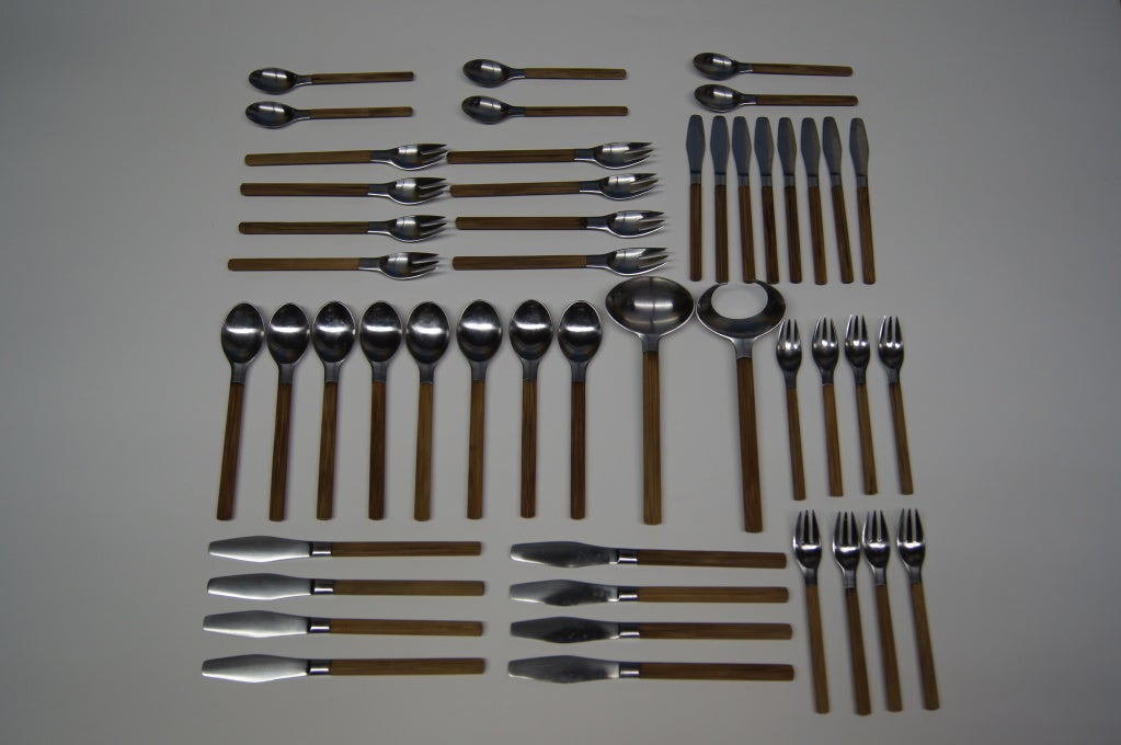 This rare set of flatware by Jens Quistgaard for Dansk includes eight place settings and two serving pieces. Each place setting features a salad fork, a dinner fork, a butter knife, a dinner knife, a tablespoon, and a teaspoon. Two teaspoons,
