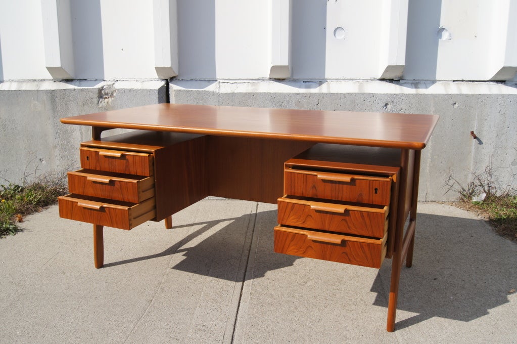 This beautiful teak desk features six drawers on one side and ample storage, both open and closed, on the other side.