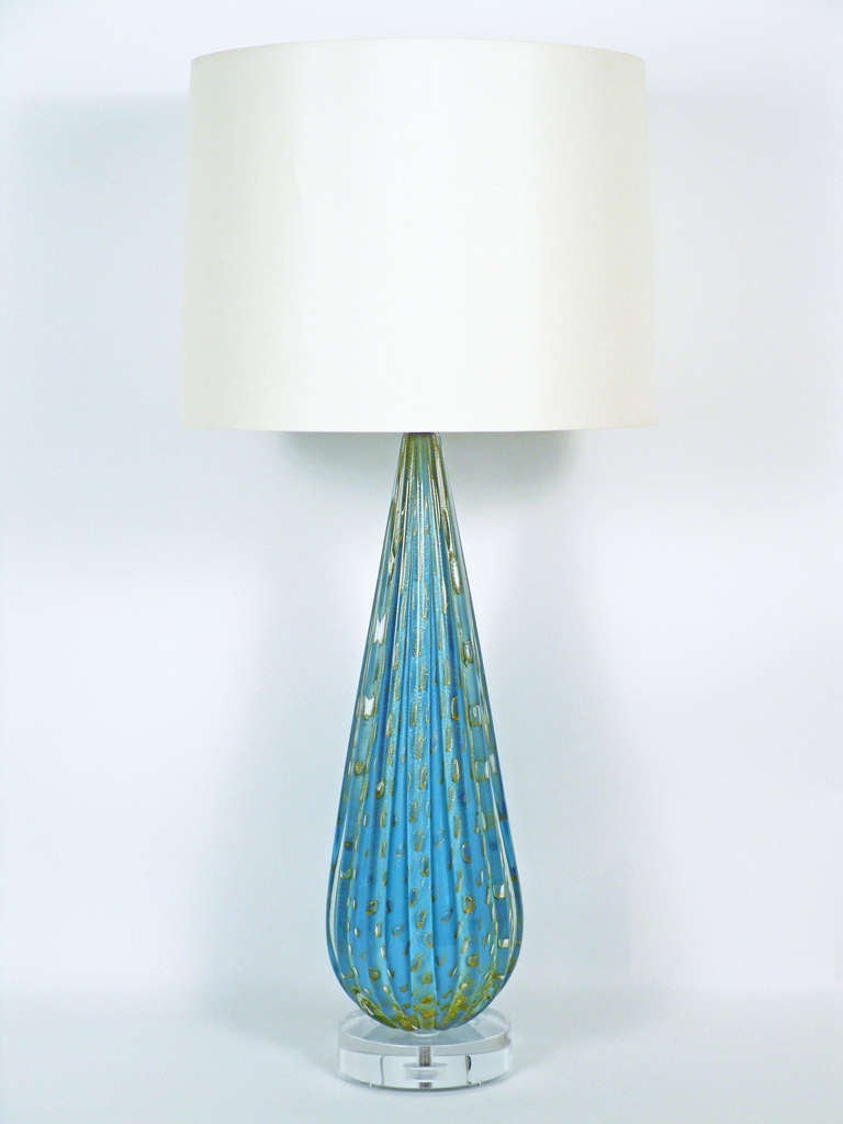 + A monumental handblown Italian glass lamp
+ Sleek teardrop profile accented by deep vertical ridges
+ Metallic gold 