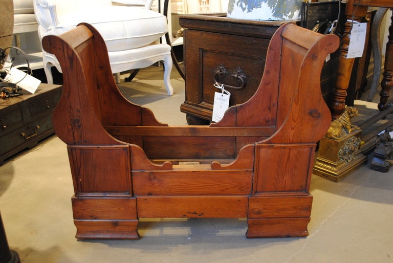 A sculptural mid-19th century carved dolls or dog sleigh bed with bracket feet.