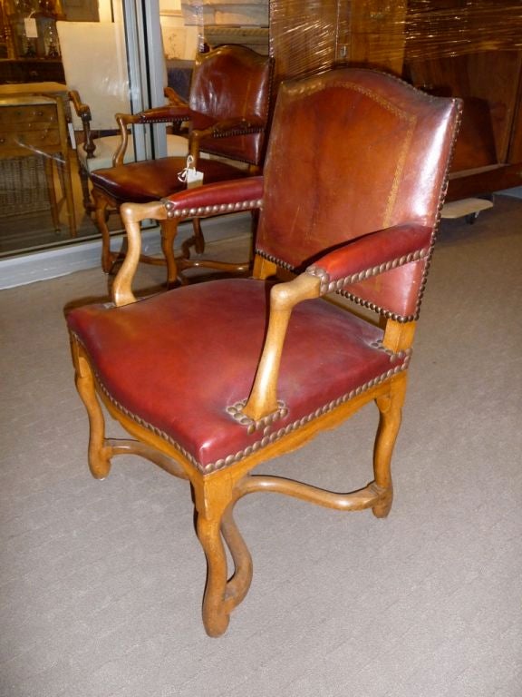Pair of 20th century Louis XIV style red leather armchairs with nailhead trim. From Banque de France. New seat.