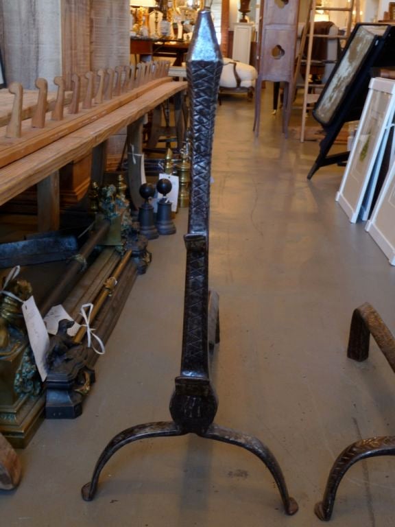 Pair of large wrought iron andirons with incised decoration and wonderful patina. Three hooks.