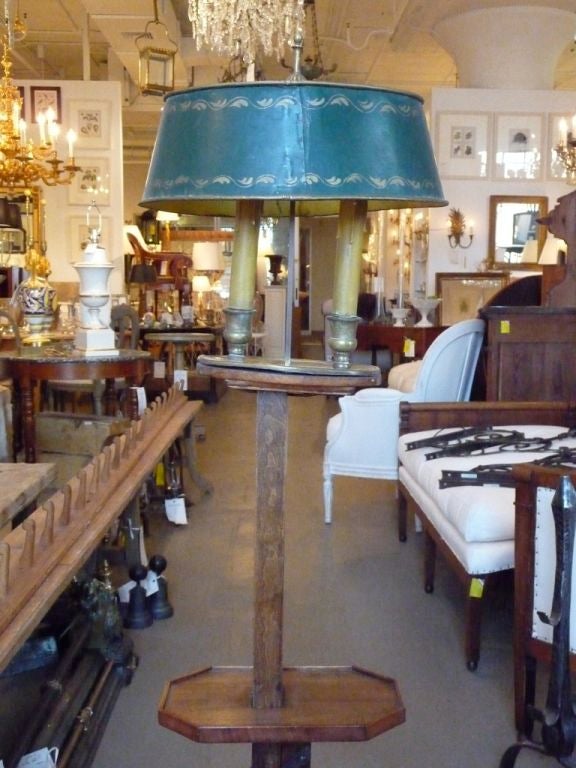 An unusual adjustable wooden floor lamp with a green tole shade.