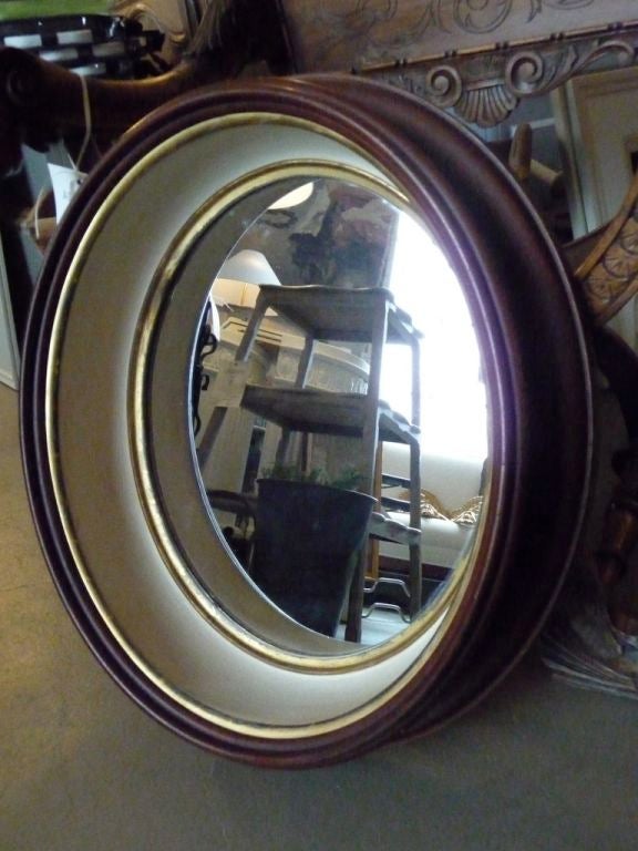 An oval walnut mirror frame with paint and gilt interior.