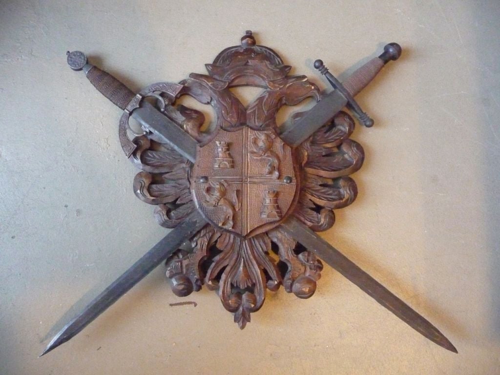 A graphic Black Forest coat of arms with crossed swords and a detailed carved back.