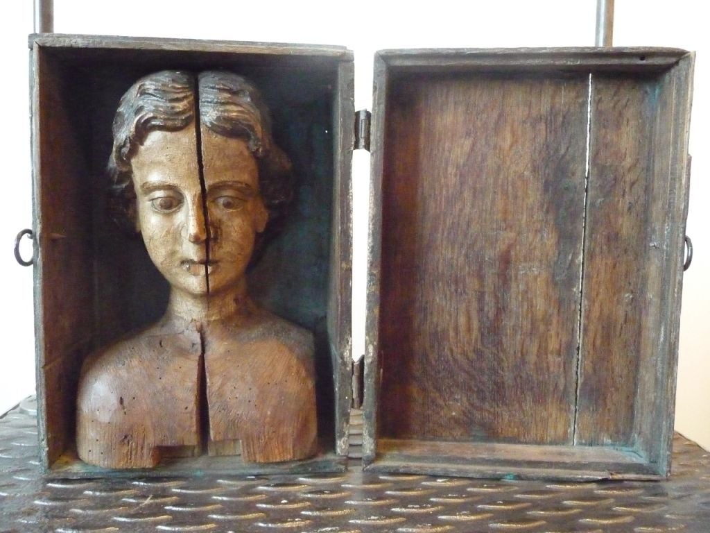 An unusual and rare carved polychrome bust mounted inside a wooden box.