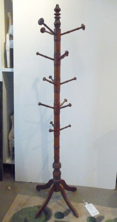 A turned Faux bamboo hall tree with 15 arms supported by a four-legged base.