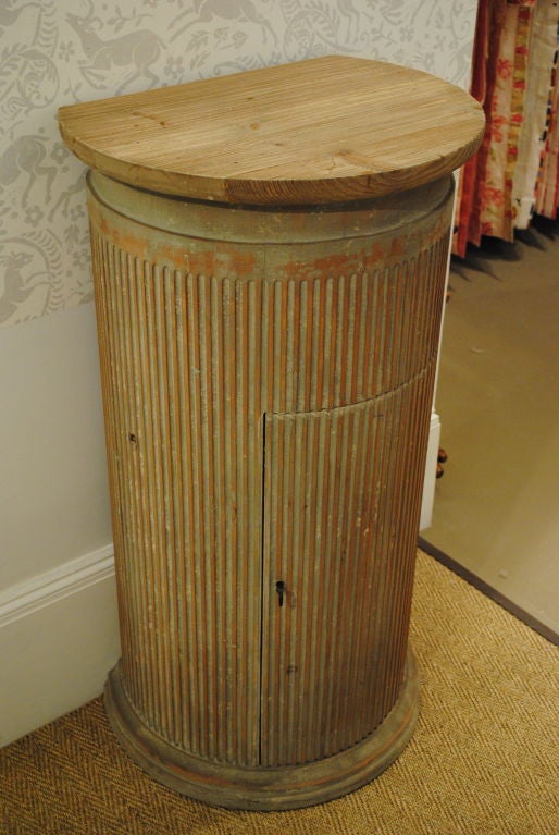 Contemporary wooden column pedestal with fluted detail, blind cut door, and two interior shelves.