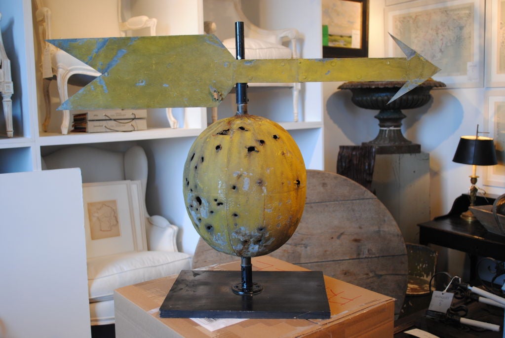 A unusual citrus colored weather vane with bullet holes. Original surface.