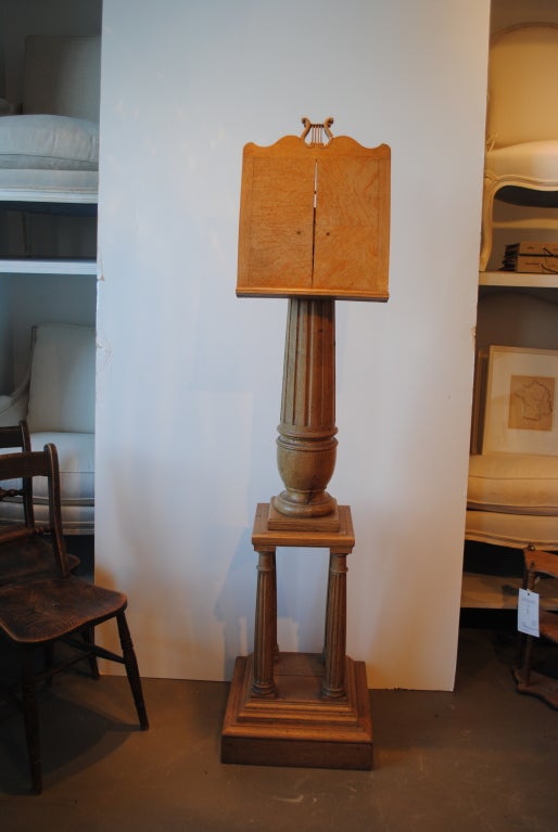 A decorative oak music stand with reeded columns. Three-piece stand with lyre cut-out on top.