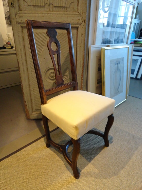 Pair of French walnut side chairs with circular cutouts. Cream upholstery with trim and nailheads. Section of nailheads missing from one of the chairs as shown in images. Comfortable and sturdy!