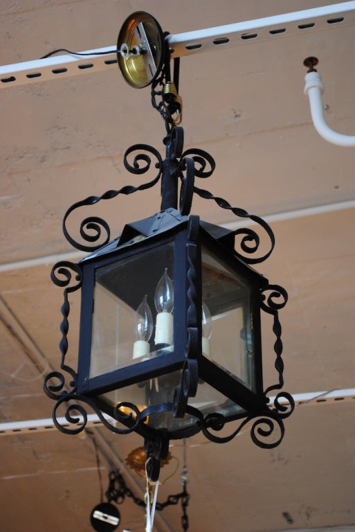 A small-scale four-sided Arts & Crafts iron lantern newly electrified with three lights and wax candle slips.
