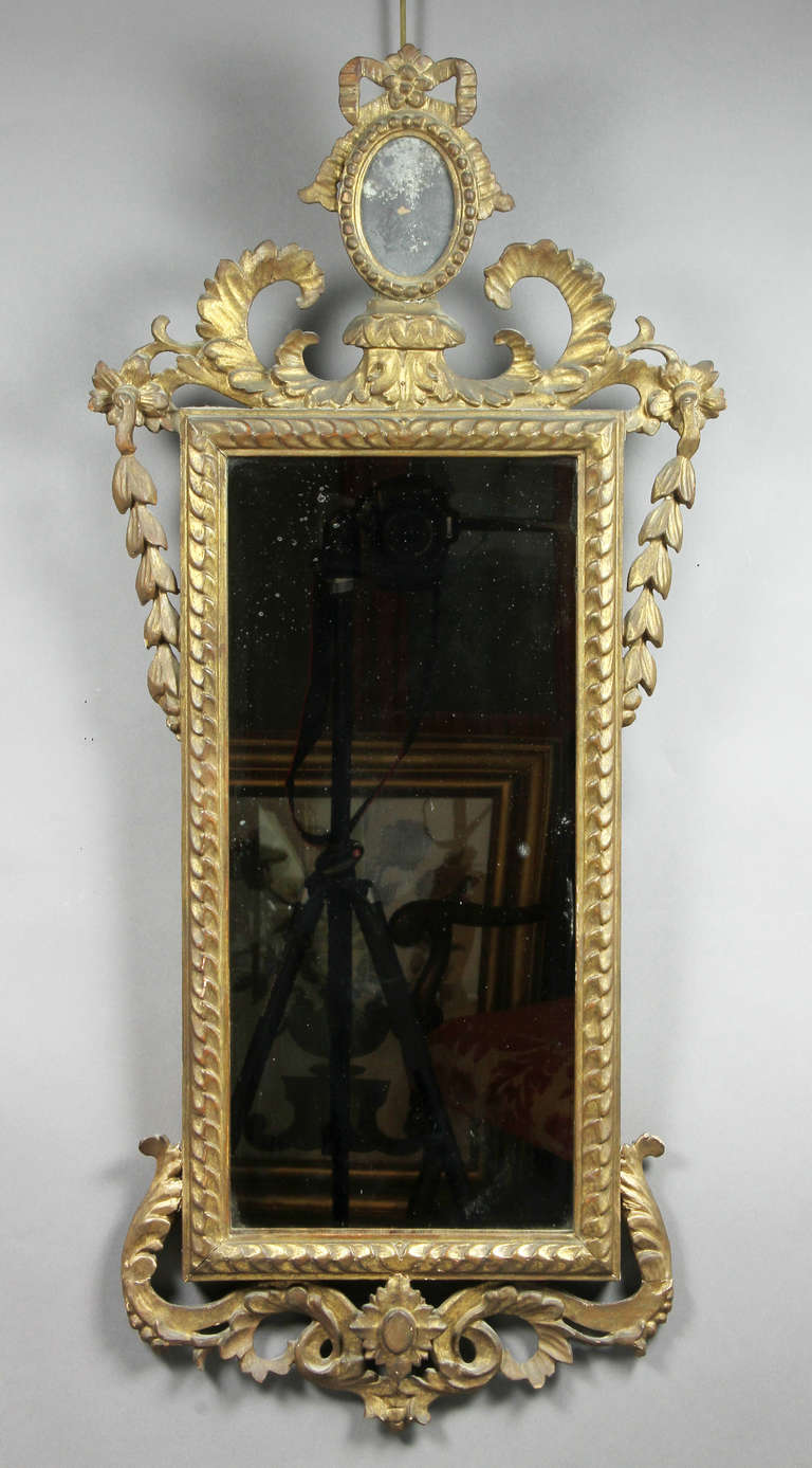 Small oval mirror above a carved frame.