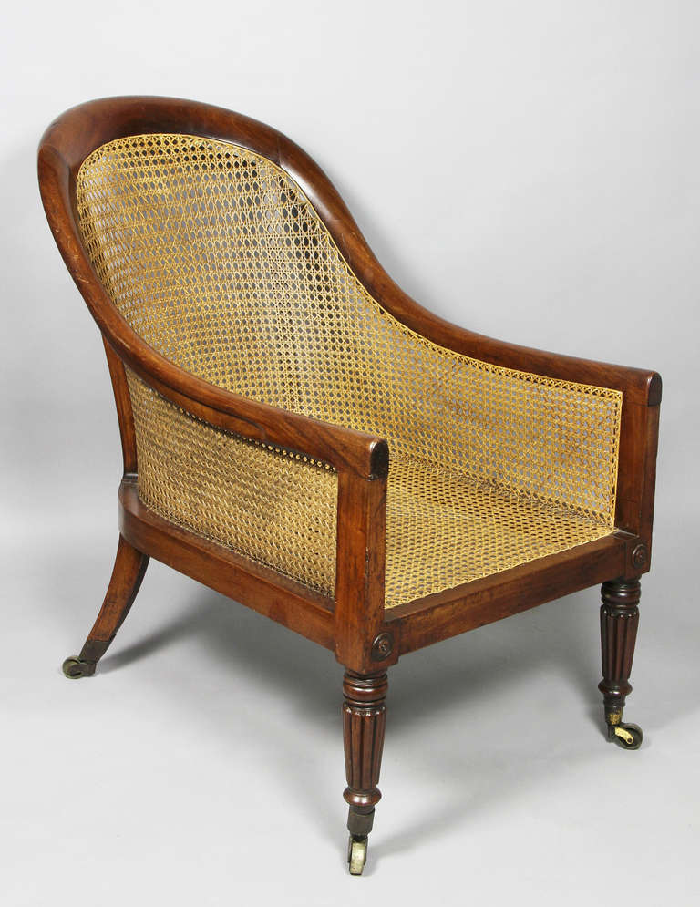 The arched back and deep seat raised on reeded legs headed by turned bosses. Rear legs swept back with casters