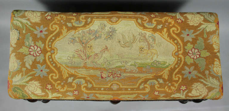 Rectangular needlepoint seat over turned legs joined by shaped stretchers , flattened bun feet. Made by George S Hunt , Pasadena , Ca