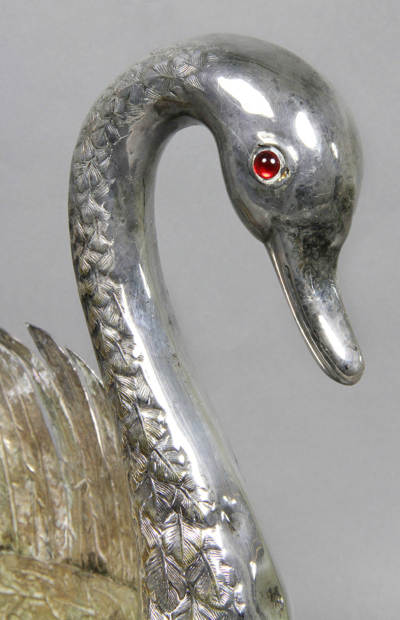 Silver plated swan form centerpiece with ruby glass eyes.