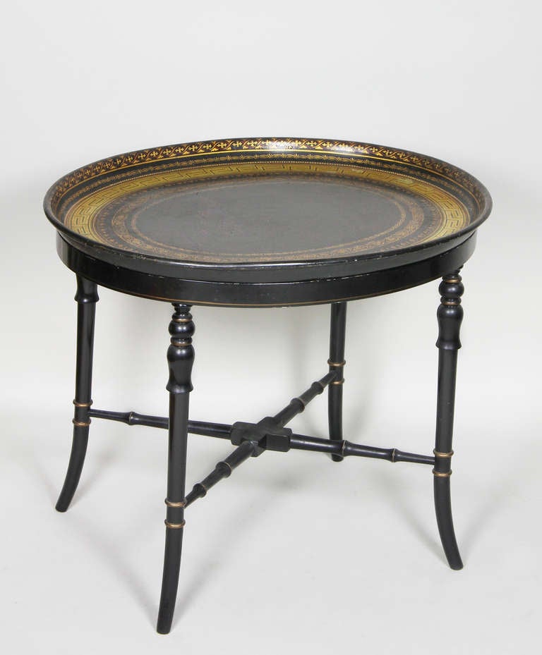 Oval with black ground and Gold Greek key and scrolling leaves. Ebonized faux bamboo base with x form stretcher.