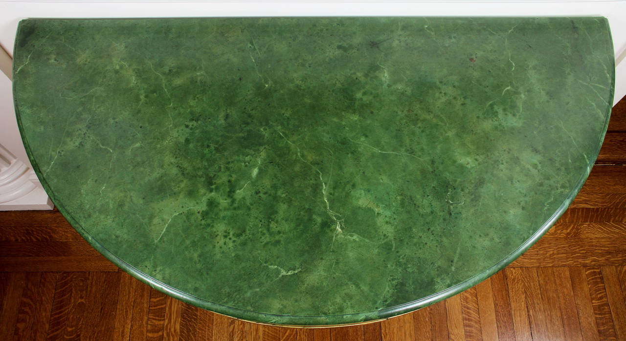 Green faux marble demilune top over a conforming frieze raised on square molded and carved tapered legs.
