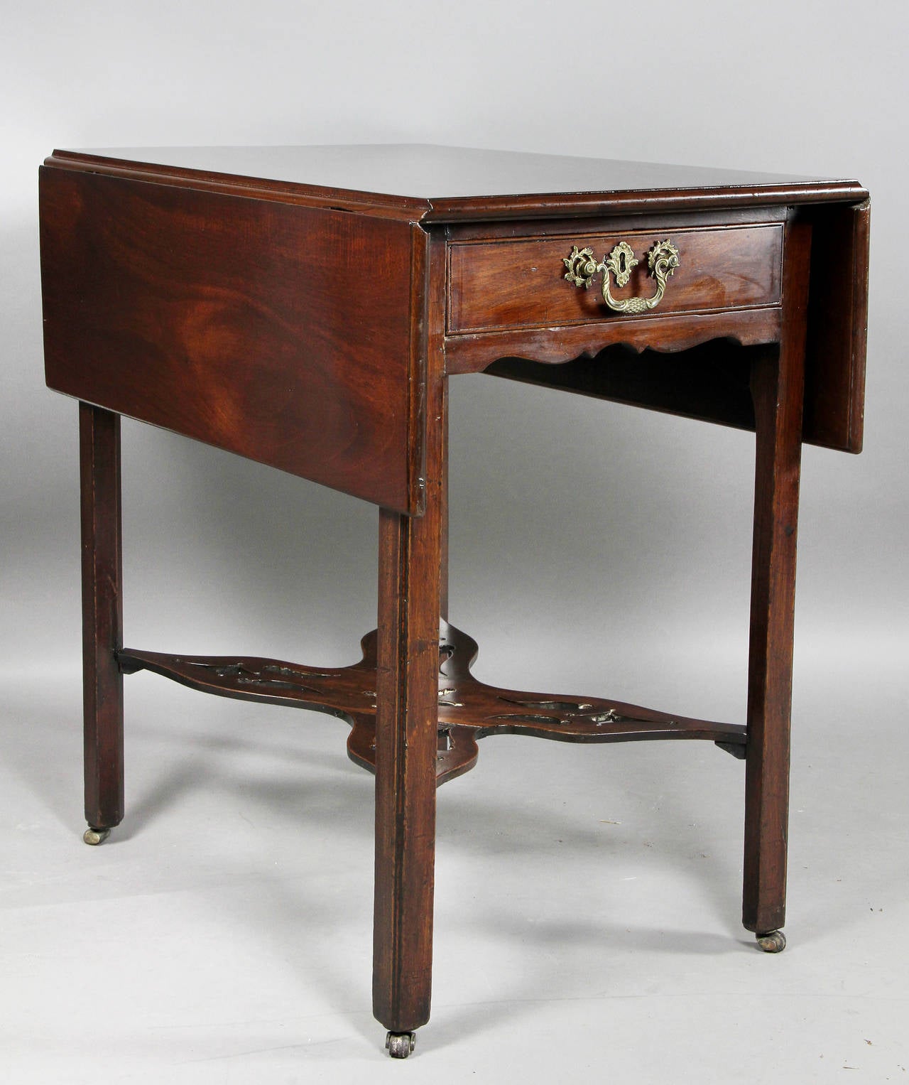 Rectangular with two drop leaves over a drawer, square legs with pierced X-stretcher, casters. Provenance; Stair And Co, NYC.